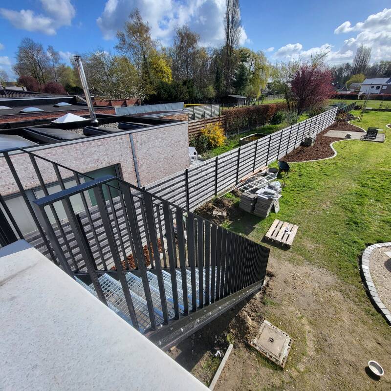 Stalen buitentrap voorzien van spijlbalustrades, afgewerkt in metalliseren + poederlak RAL 9005