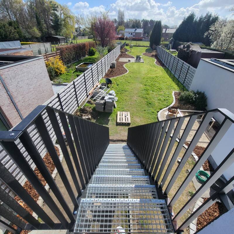 Stalen buitentrap voorzien van spijlbalustrades, afgewerkt in metalliseren + poederlak RAL 9005