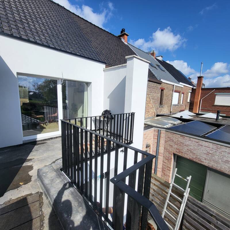 Stalen buitentrap voorzien van spijlbalustrades, afgewerkt in metalliseren + poederlak RAL 9005
