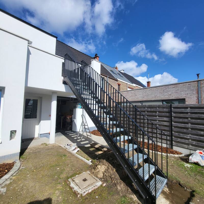Stalen buitentrap voorzien van spijlbalustrades, afgewerkt in metalliseren + poederlak RAL 9005