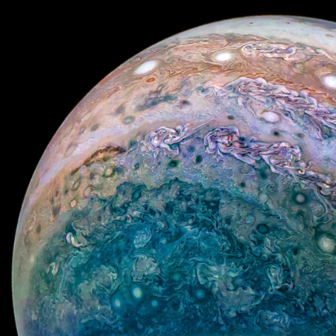 Colorful view of Jupiter's colorful bands and swirling cloud patterns, showing blues and browns. 