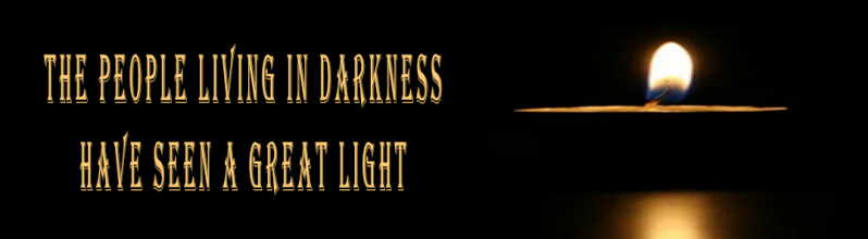 A single candle flame burning in darkness beside the words ‘The people living in darkness have seen a great light’ — the dawn of light
