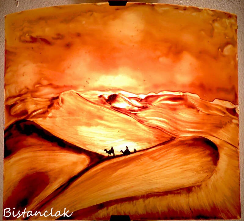 applique murale paysage sur mesure de couleur sable orangée décorée d'un paysage désertique et de la lointaine silhouette d'une caravane du désert marchant dans les dunes.