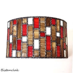 cette applique en demi-cylindre coloré offre un design linéaire et géométrique, elle est en verre de couleur rouge, ivoire et sable brun chamarré.