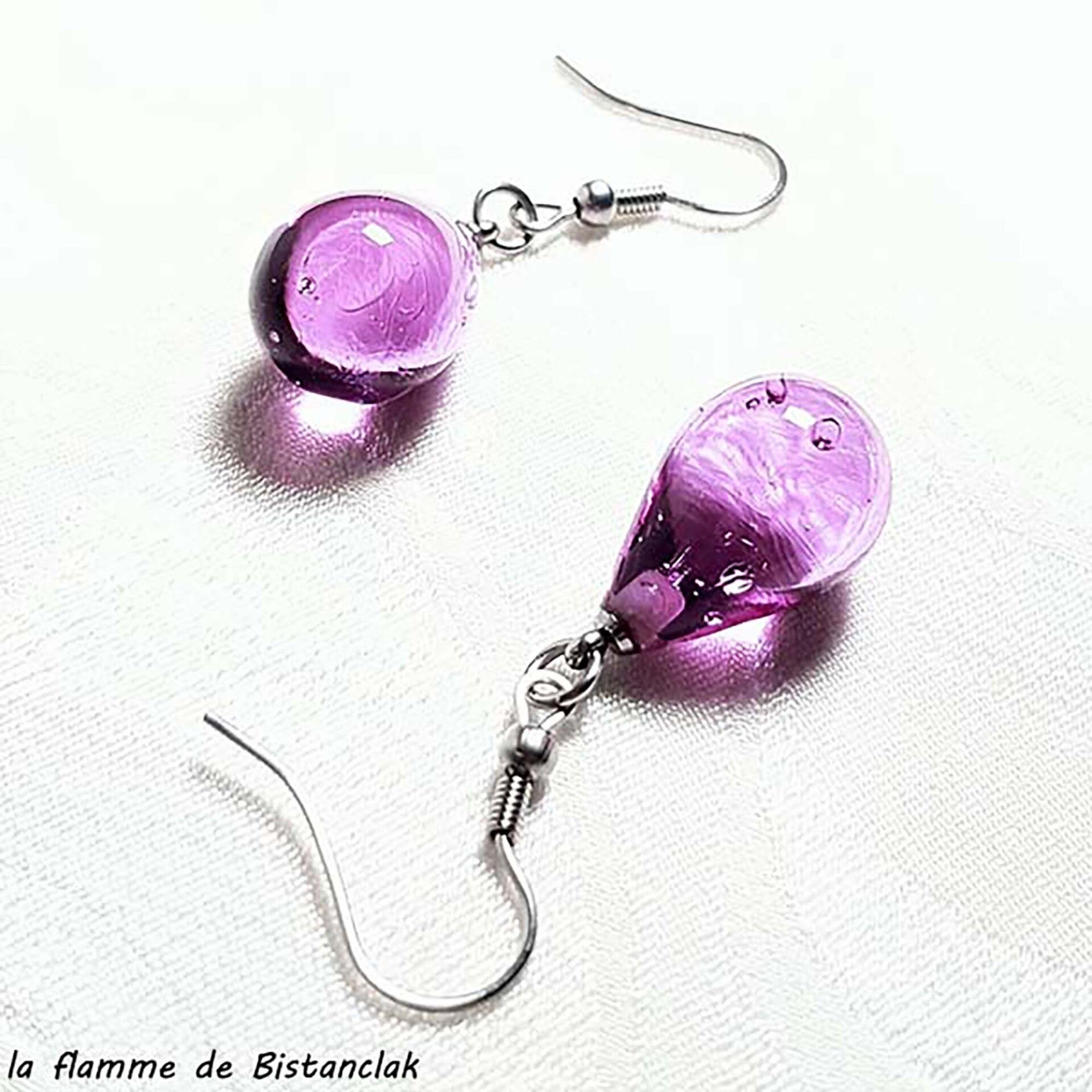 une paire de boucles d'oreilles en verre en forme de goutte de couleur bleu turquoise transparent