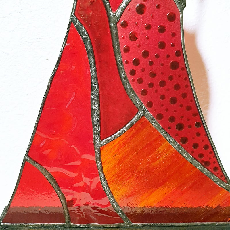 gros plan sur les finitions décoratives effectuées sur les soudures entre les pièces de verre qui composent la robe