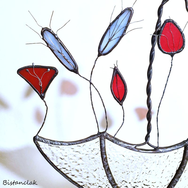 gros plan sur les fleurs des champs rouges et grises ornées des fils de cuivre travaillés pour donner un aspect plus réaliste à cette déco vitrail.