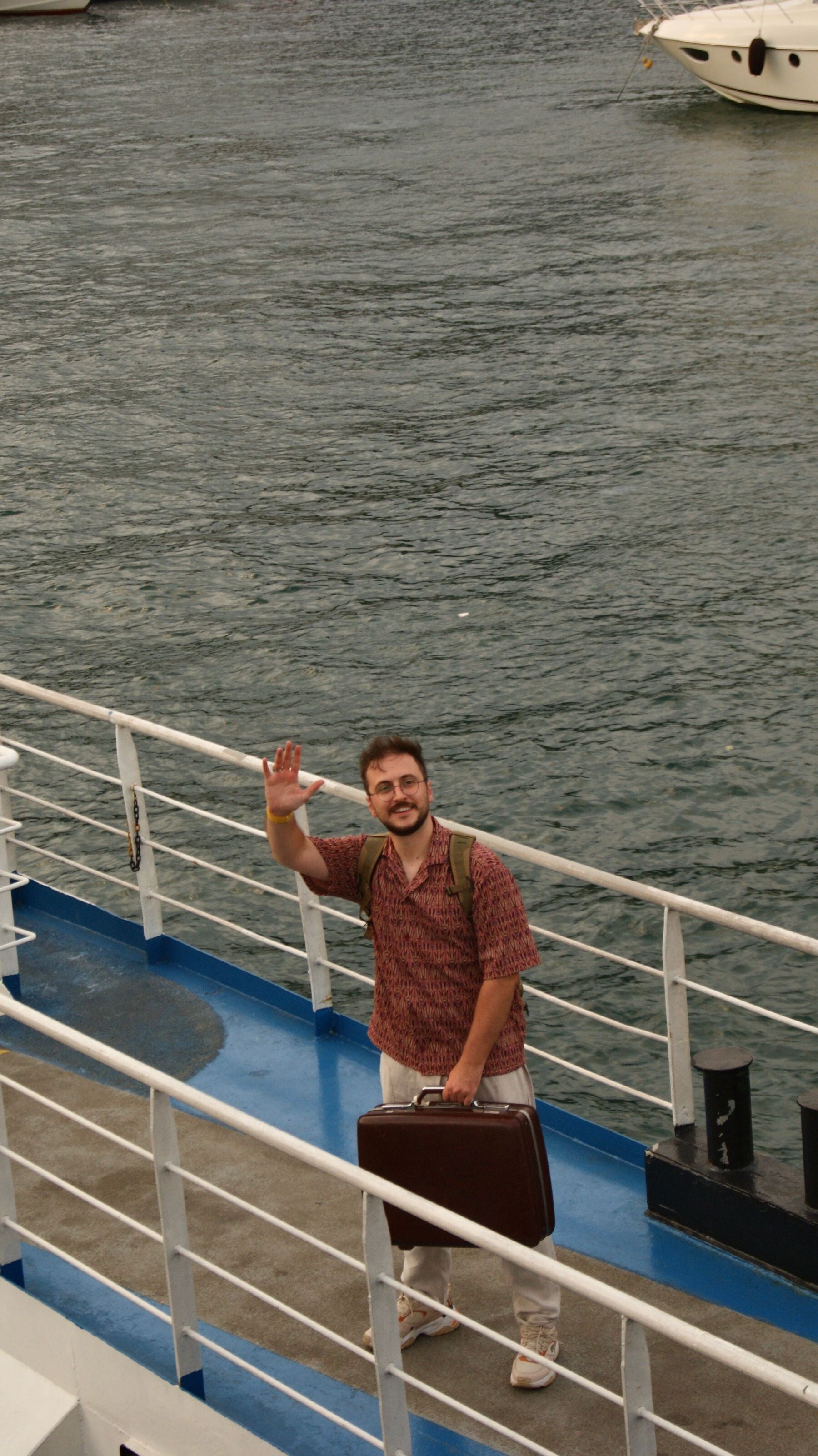 A traveler carrying luggage while boarding a passenger ship, representing the final steps of embarkation.