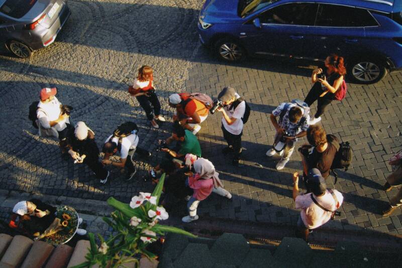 Tourists taking photographs while exploring a city street
