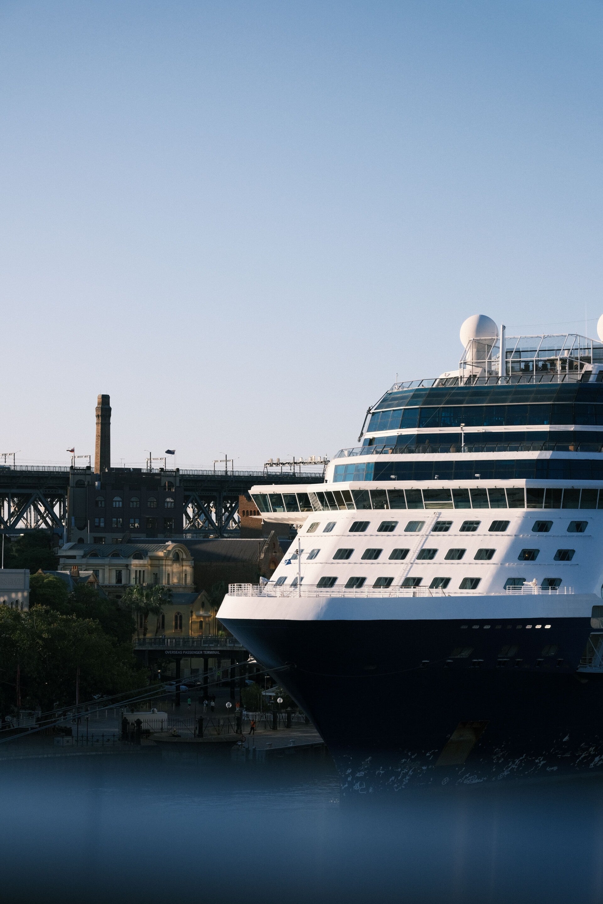 A large cruise ship docked beside a city harbor, illustrating how a port’s location affects usable sightseeing time.