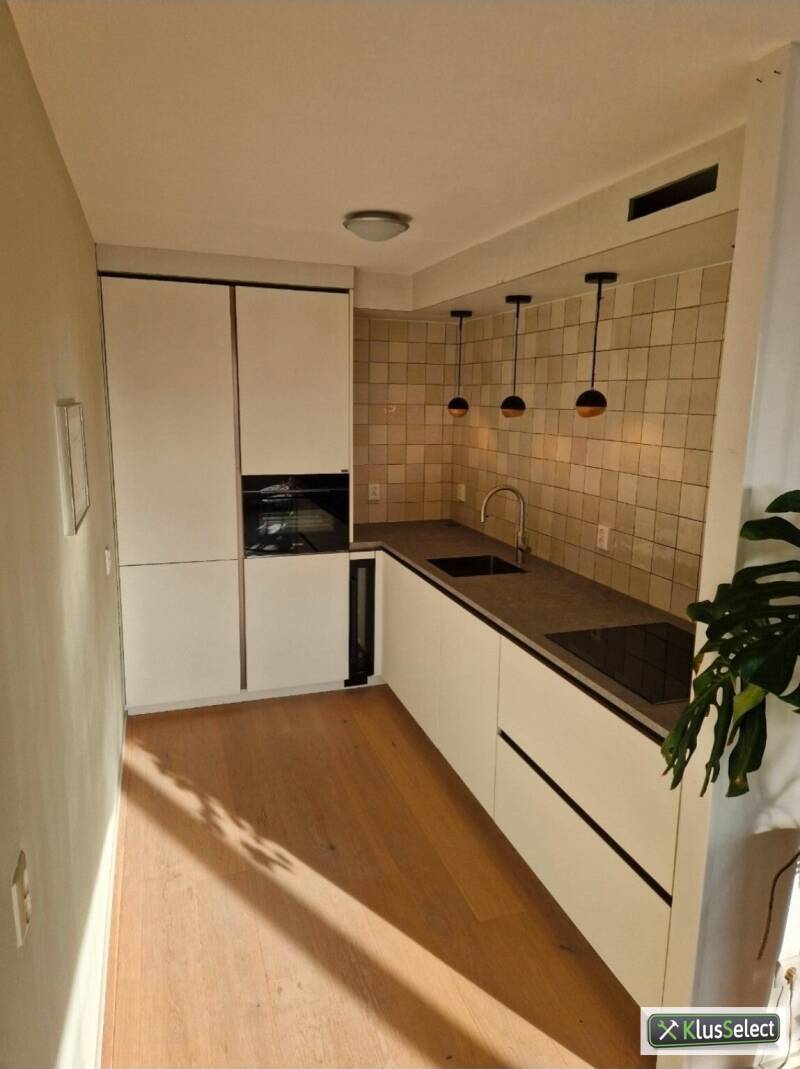 Lichte keuken met drie hanglampen boven het werkblad