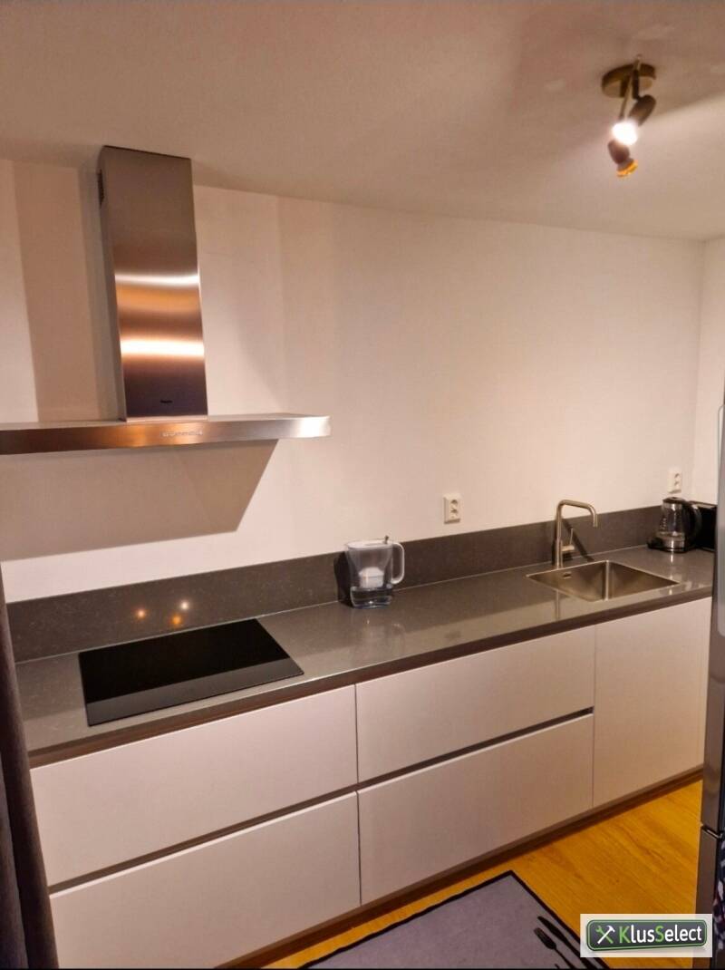 Witte keuken met inductiekookplaat en RVS afzuigkap