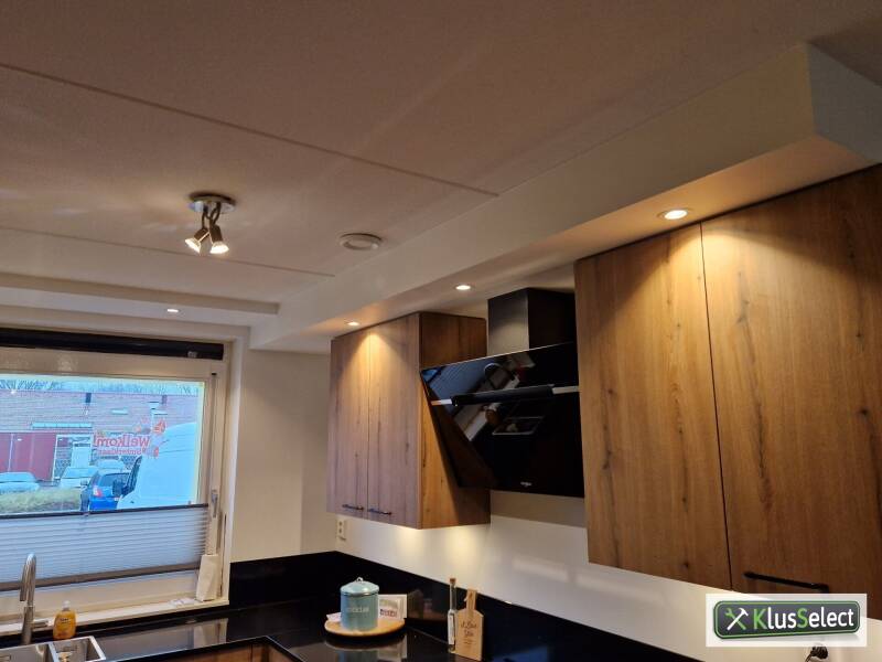 Houtkleurige bovenkasten met zwarte afzuigkap