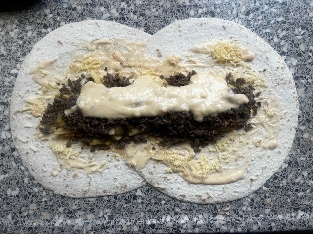 5. Giet een flinke pollepel oude kaassaus over het gehakt heen