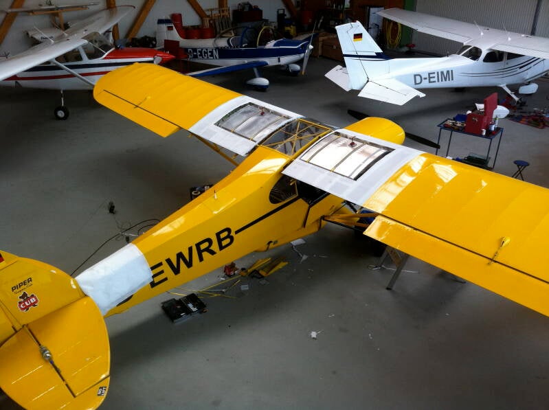 Modified Piper Super Cub with CubCrafters wing tanks installed in German hangar before bush flight to Kenya – aircraft prepped for extreme African flying conditions by Marcel Romdane. An African Odyssey, Part XII / Containerised Glory: The Idiot Has Lande