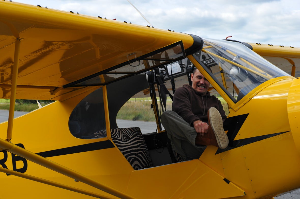 Marcel Romdane forcefully reenters his yellow Super Cub like a drunk yogi with a death wish. “From Riches to Rags: An African Odyssey.” Part XII, The idiot has landed. Zebra seat. No plan. Campfire Syndicate LLC documents everything.