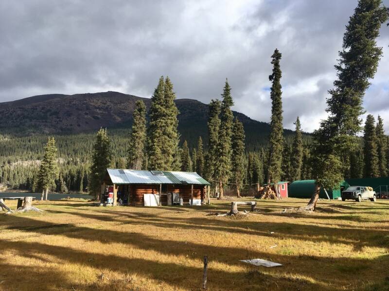 Log cabin headquarters in the Yukon wilderness—home, kitchen, and unfiltered management aroma—photographed by Marcel Romdane during his “What Could Possibly Go Wrong?” memoir disaster chapter.