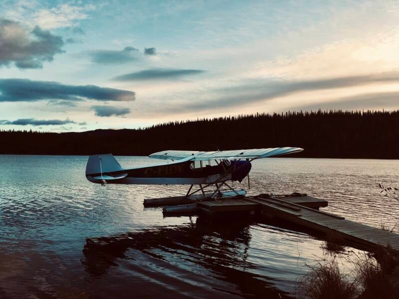 A float-equipped bush plane moored to a lonely dock on a remote Yukon lake at sunset—serene in appearance, but dripping with irony. Behind the postcard lies a moral sinkhole of trophy egos, rotting ethics, and enough body odor to trigger an evacuation.