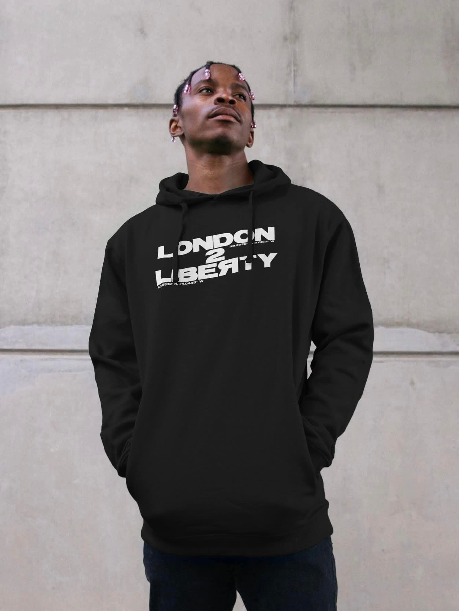 A man wearing a black hooded top with London 2 Liberty Logo in the chest area