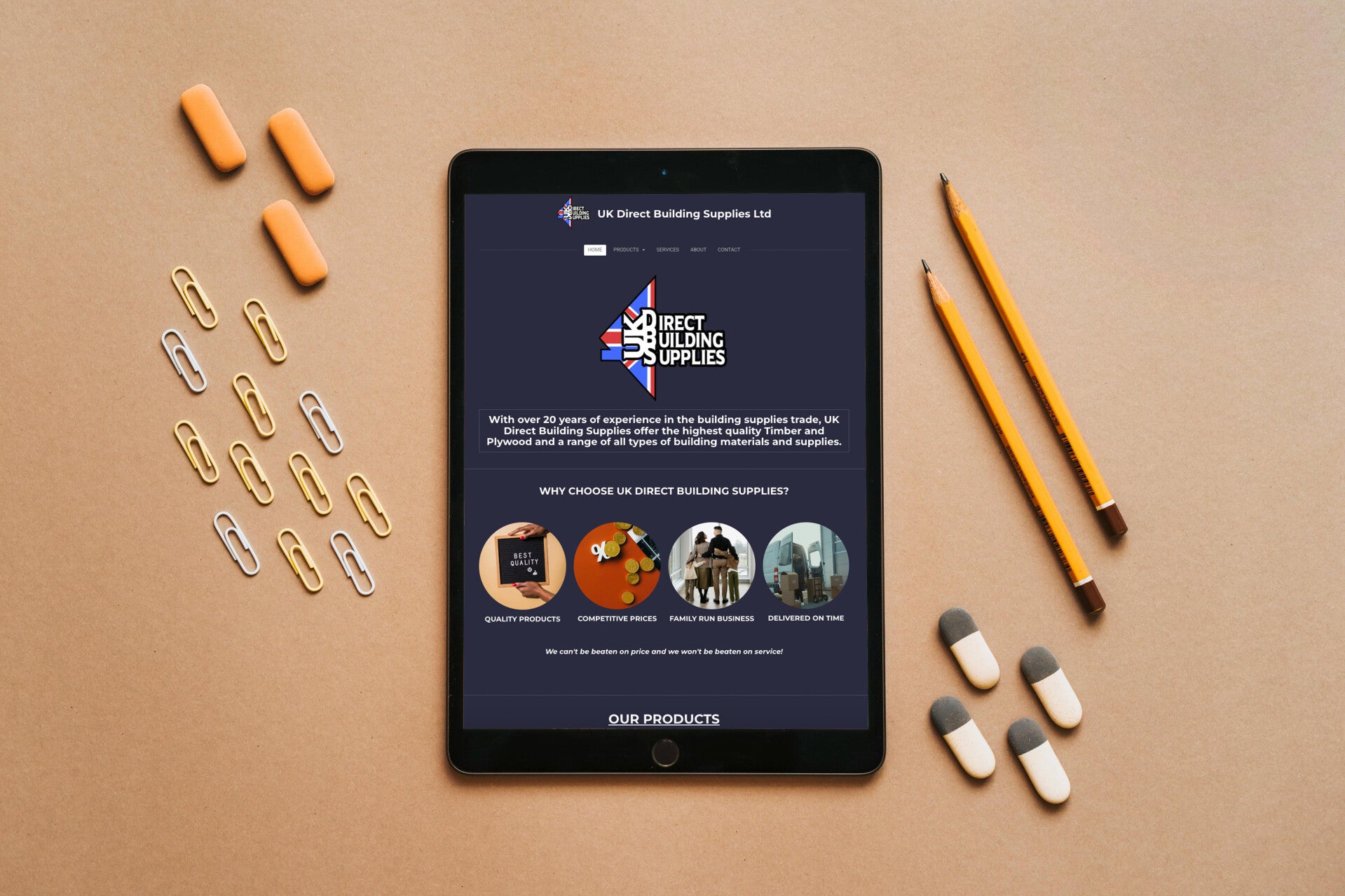 picture of an tablet with a website that emilly created on the screen, On the left there are paperclips and on the right sit two pencils and 4 rubbers