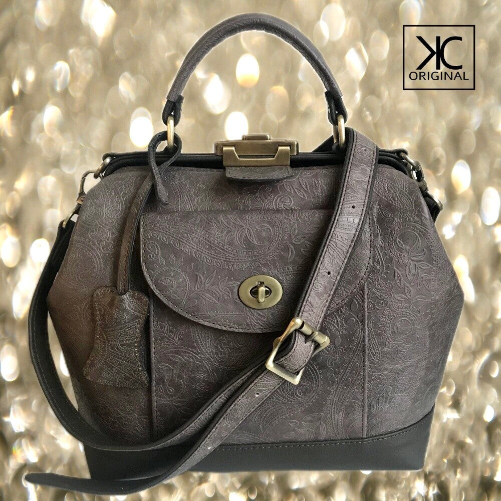 Dokterstas in leverbruin leer met mandala reliëf. Verstelbare schouderband, afsluitbaar zak op voorkant. Leren beugeltas.