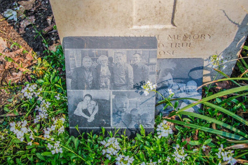Nabestaanden leggen foto's neer bij de graven van jonge militairen uit de tweede-wereldoorlog.