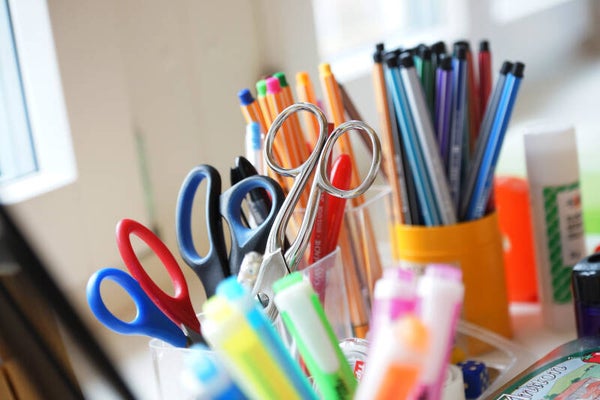 Bunte Stifte und Scheren am kreativen Arbeitsplatz