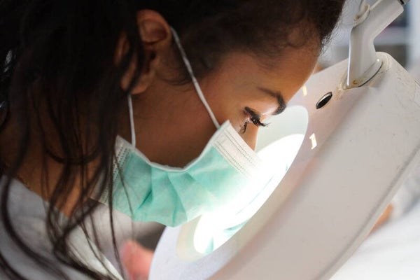 Kosmetikerin bei präziser Beautybehandlung mit Lupenlampe
