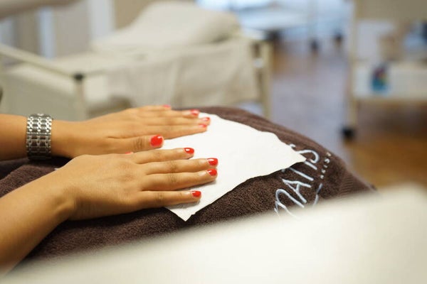 Gepflegte Hände mit rotem Nagellack im Kosmetikstudio