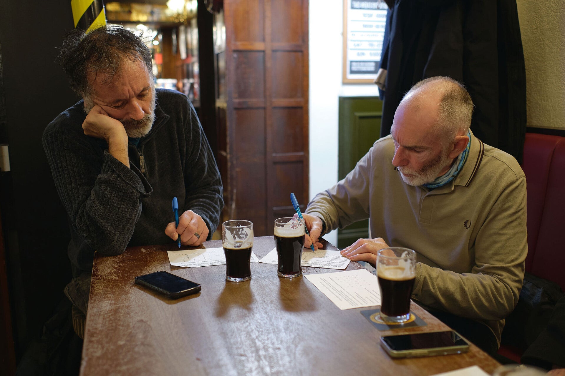 Four young women in a modern  bar, sat round table laughing at pub quiz at Whitby Hot Chocolate Festival