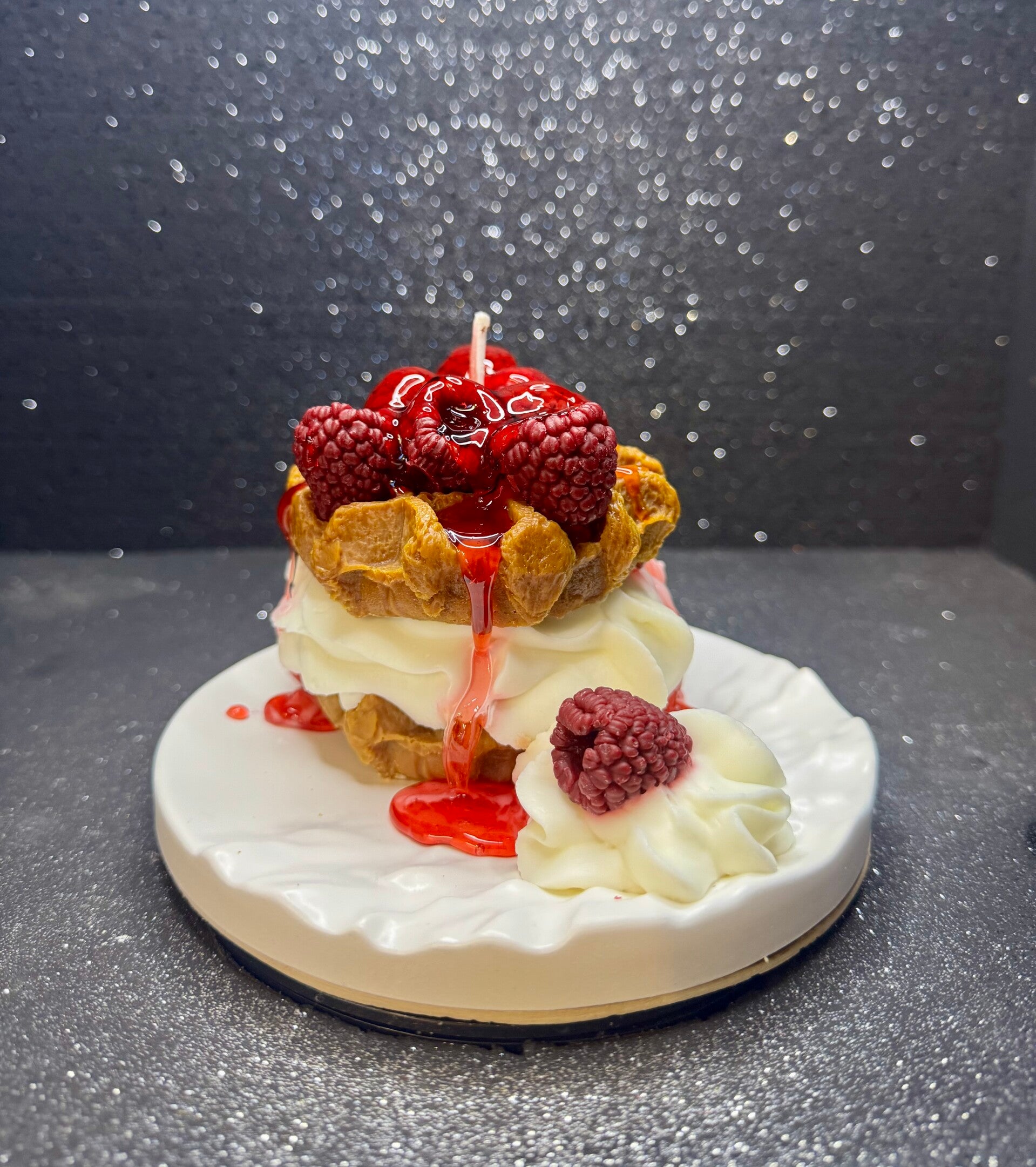 Waffelkerze mit Himbeeren auf Keramik Teller