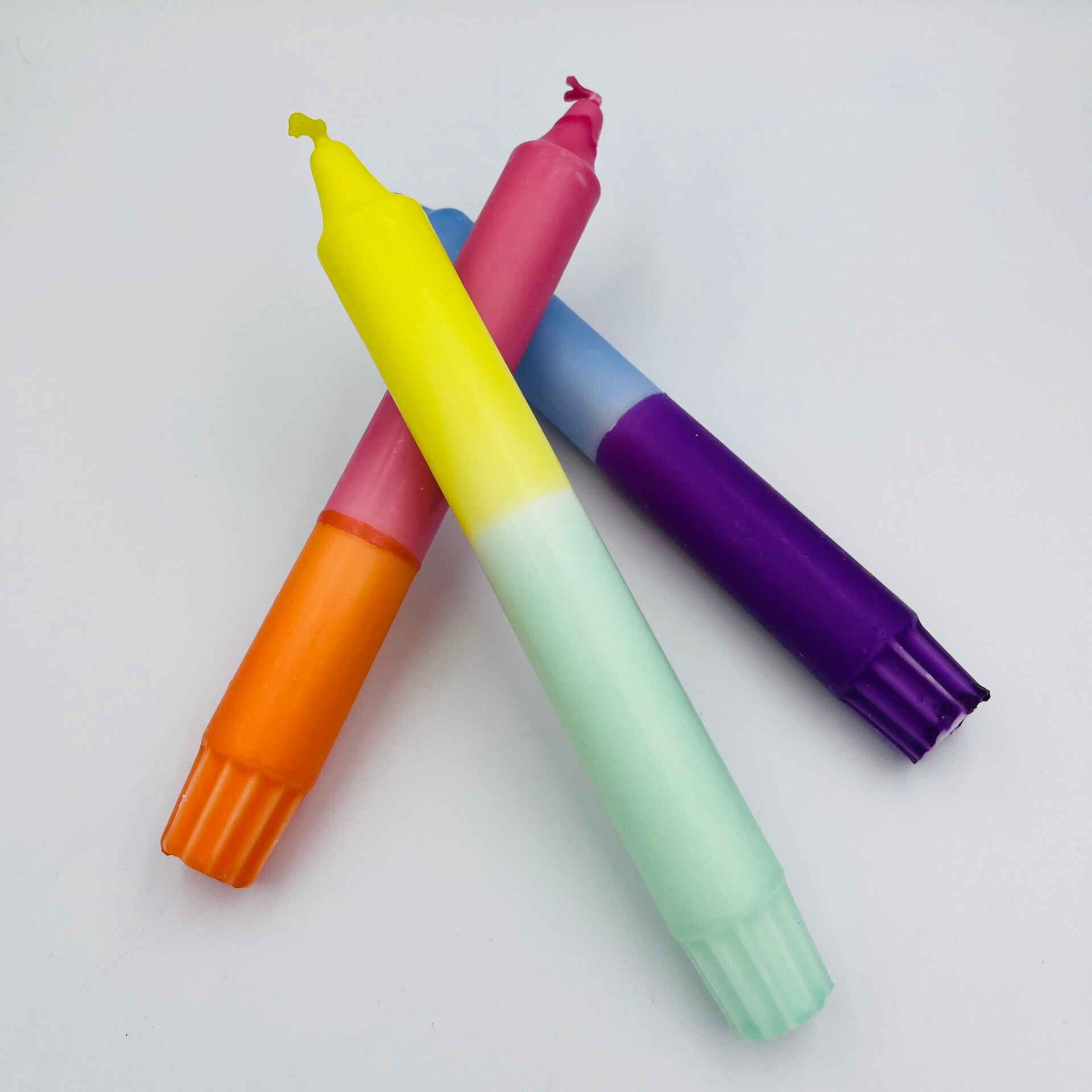 Originele verjaardagscadeaus! Op de afbeelding drie leuke dip dye kaarsen: kaarsen die bestaan uit verschillende kleuren.