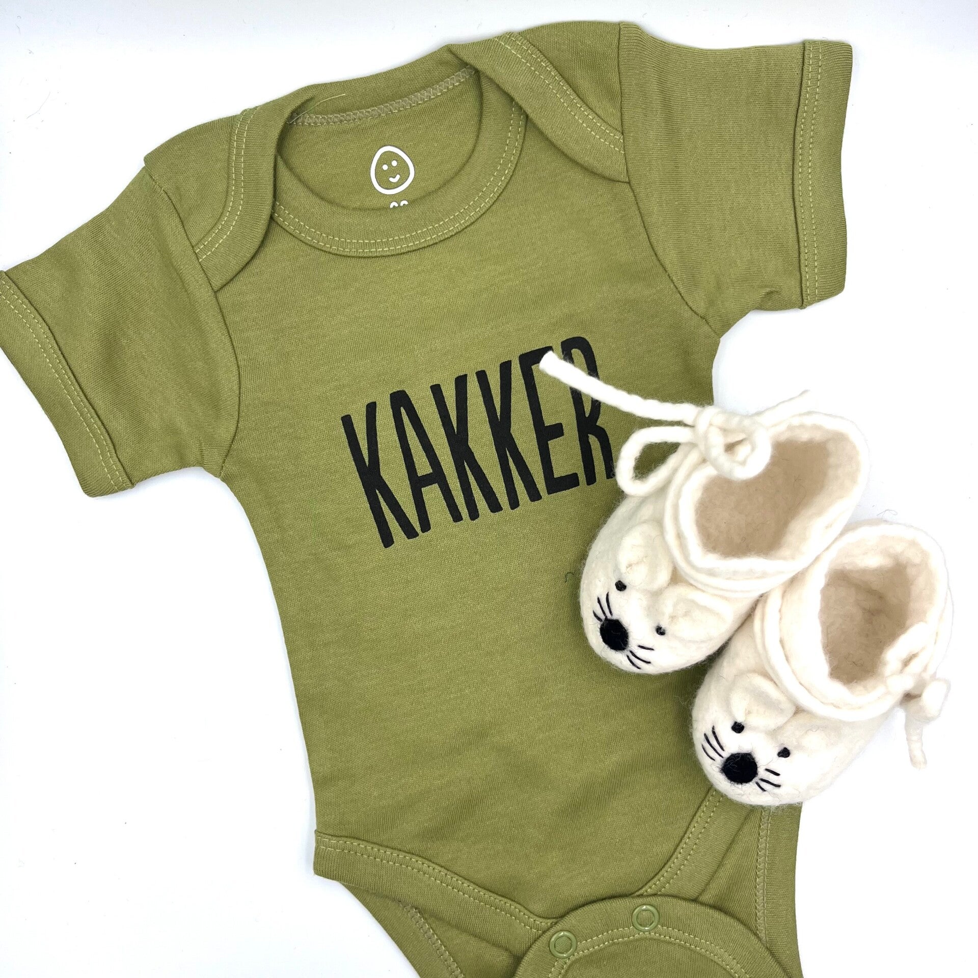 Babycadeaus! Op de foto een rompertje met de tekst KAKKER erop en lieve slofjes.