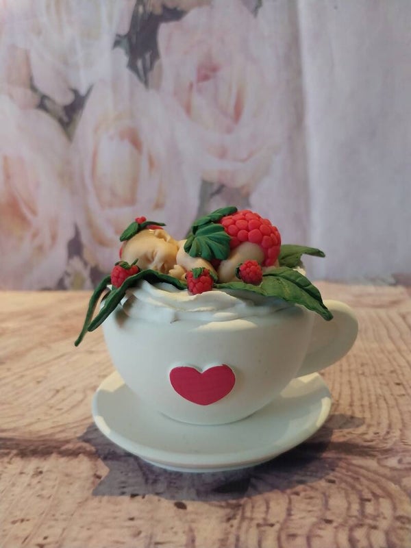 Bébé fimo fille framboise sur tasse