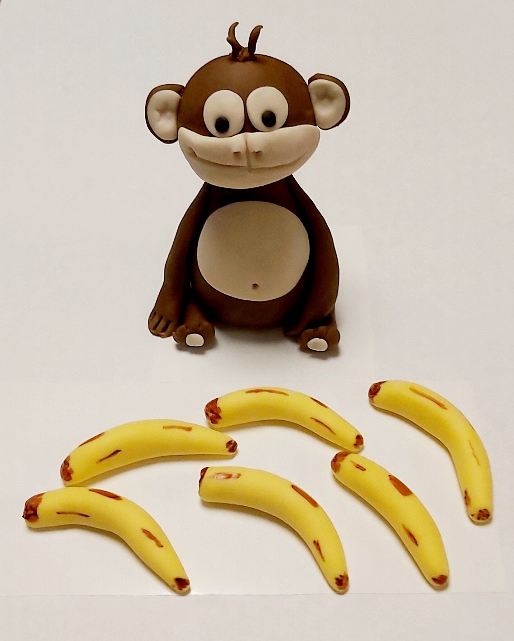 Geboetseerde aap met 6 bananen