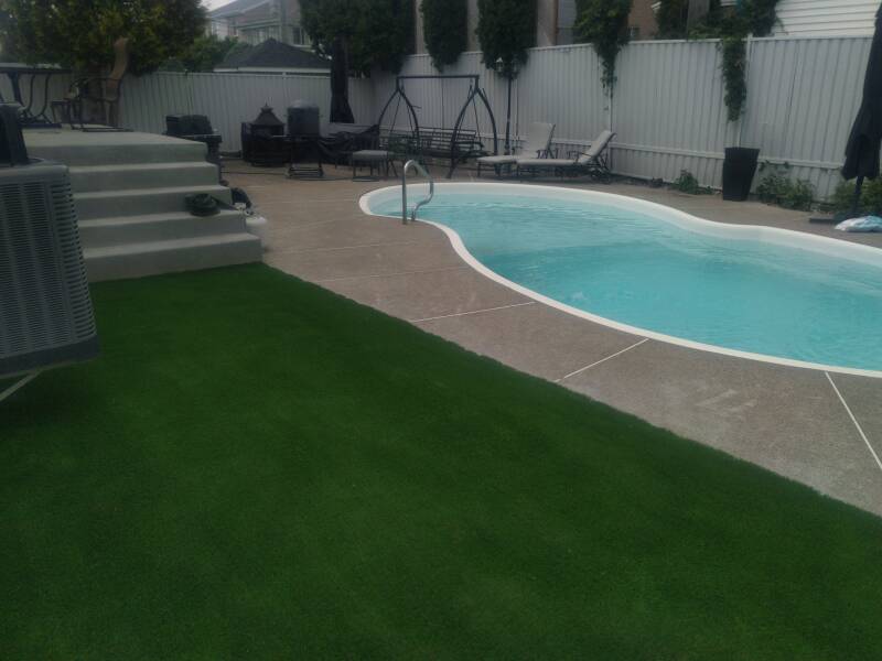 Exterior landscaping with artificial grass installed around a property in Laval, Quebec