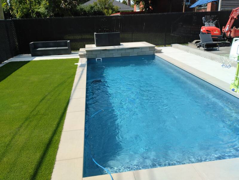 Artificial turf landscaping around residential swimming pool in Montreal, Quebec