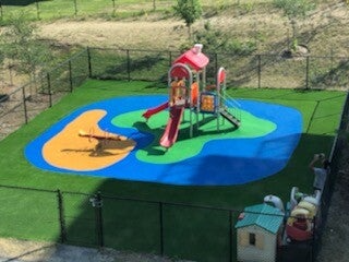 Aire de jeu sécuritaire d’un CPE à Montréal avec surface en caoutchouc amortissante et gazon synthétique installé