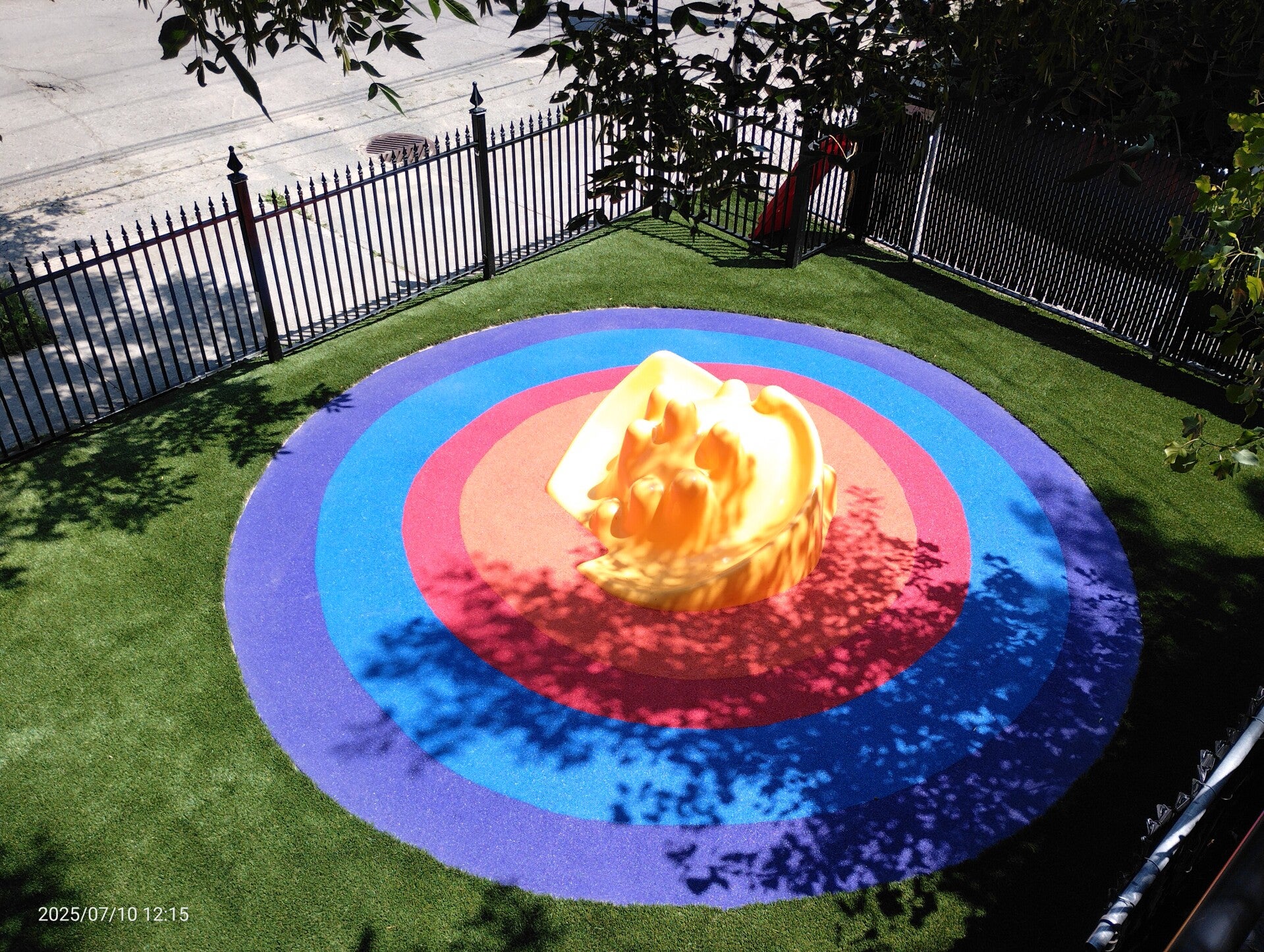 Montreal daycare playground with rubber rainbow design and artificial turf