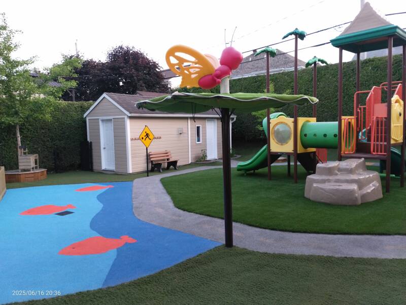 Daycare playground with rubber surface, artificial grass, and play module