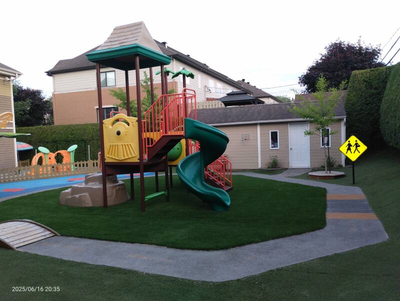 Safe outdoor play area at daycare with artificial grass and rubber surfacing
