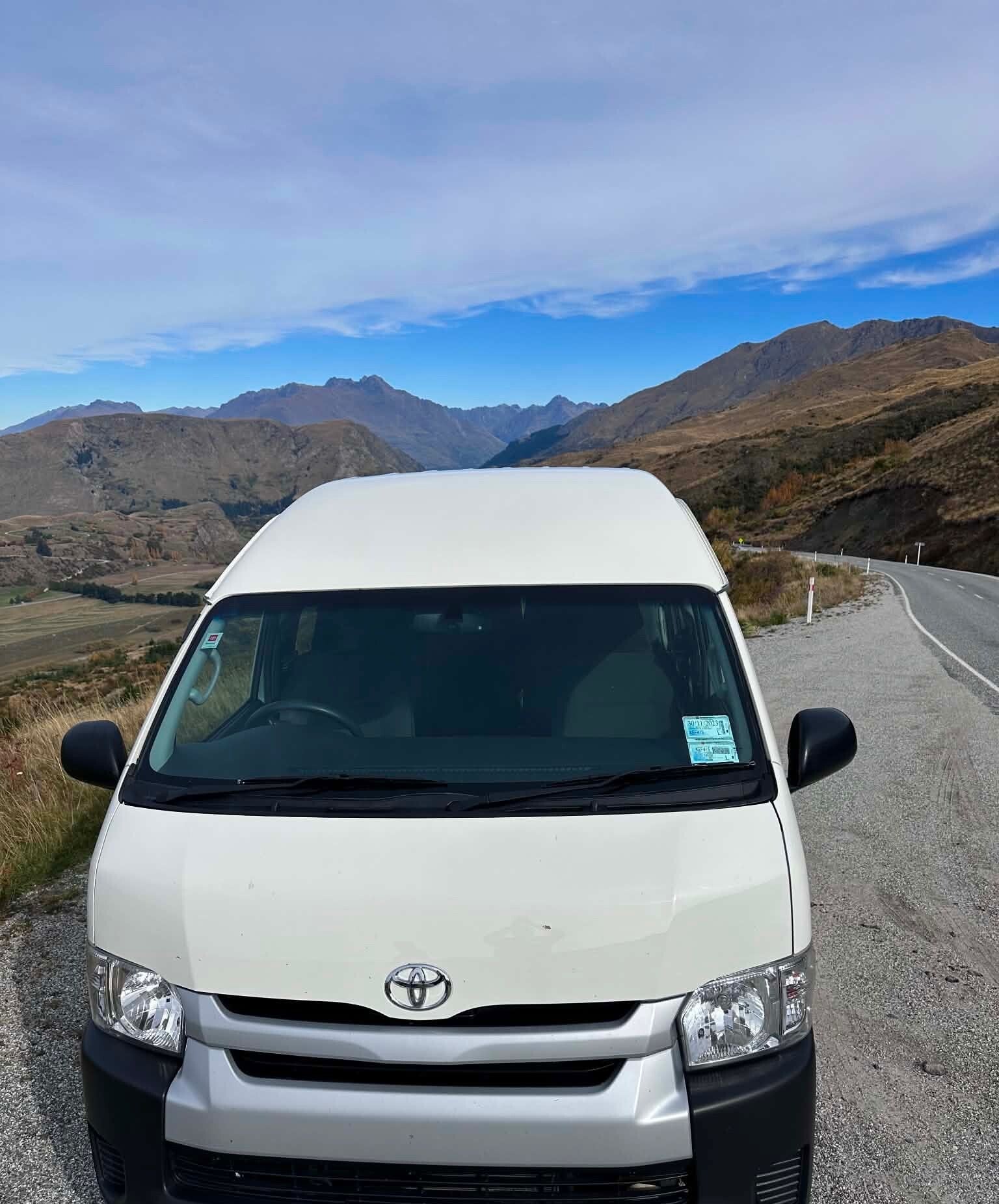 Toyota maxi taxi infront of the mountrains in Queenstown