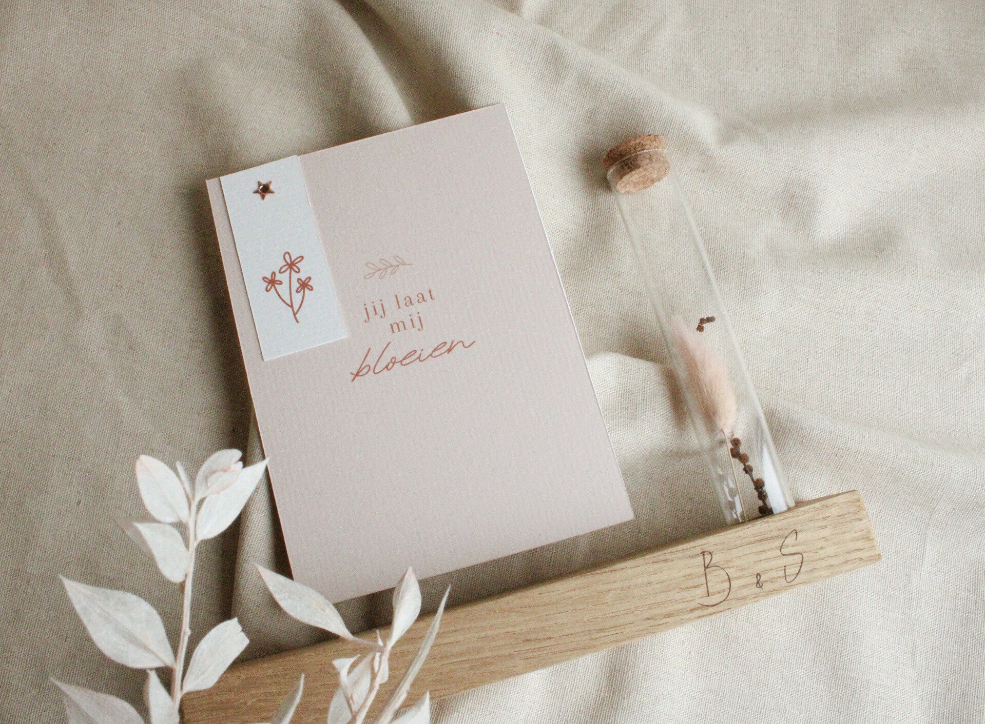 Houten blokje met ansichtkaart en glazen reageerbuisje