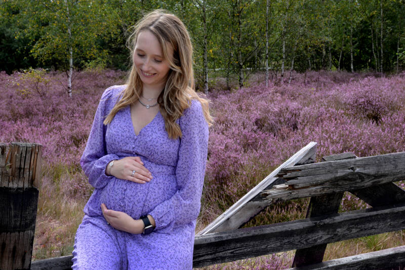 zwangere dame op houten hek