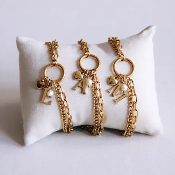 Dubbel schakelarmbandje met letter, hartje en mini parel - goud
