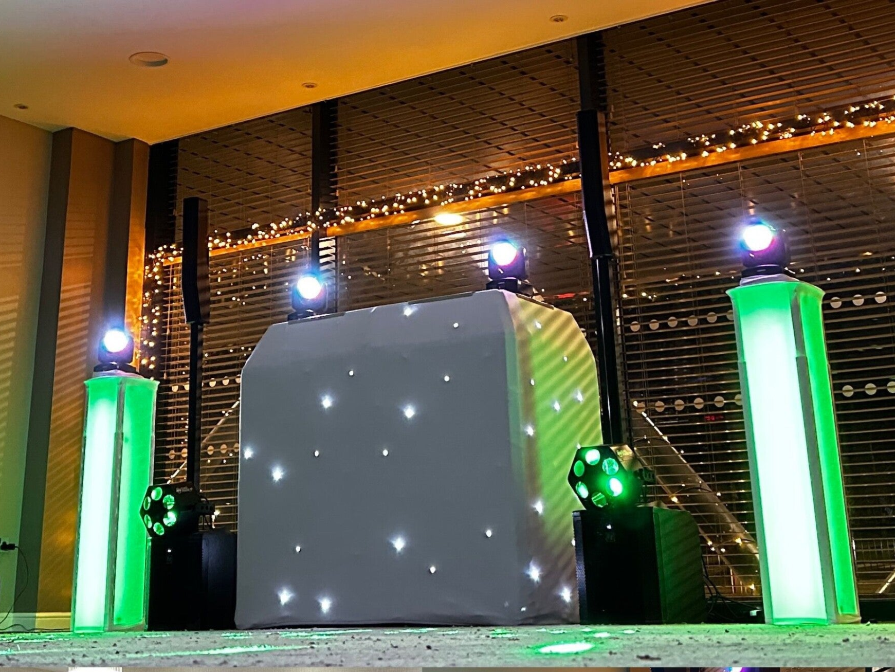 Premium evening wedding DJ setup with booth and lighting