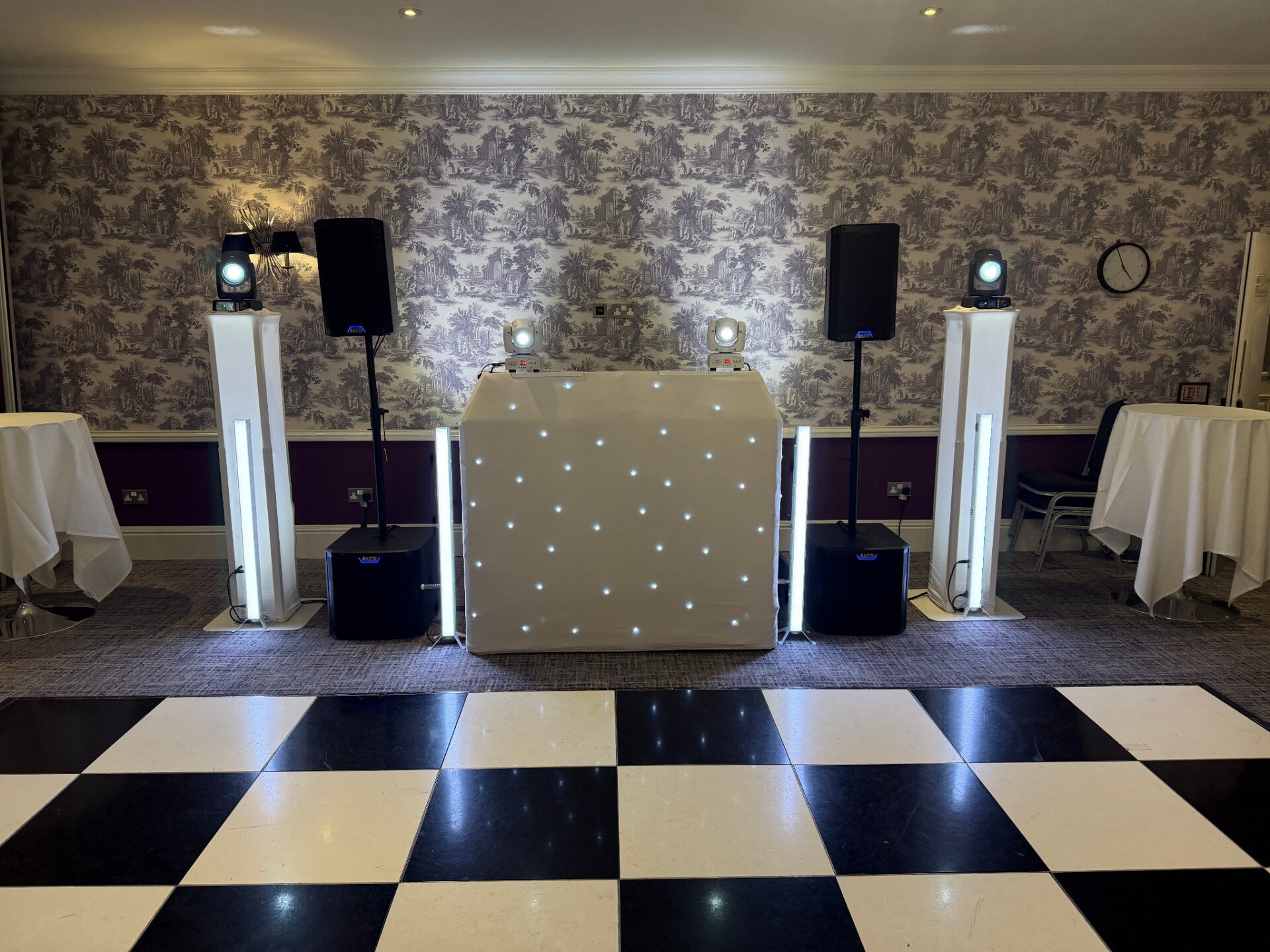 Symmetrical MHX wedding DJ setup with a white starlit booth and two illuminated podiums