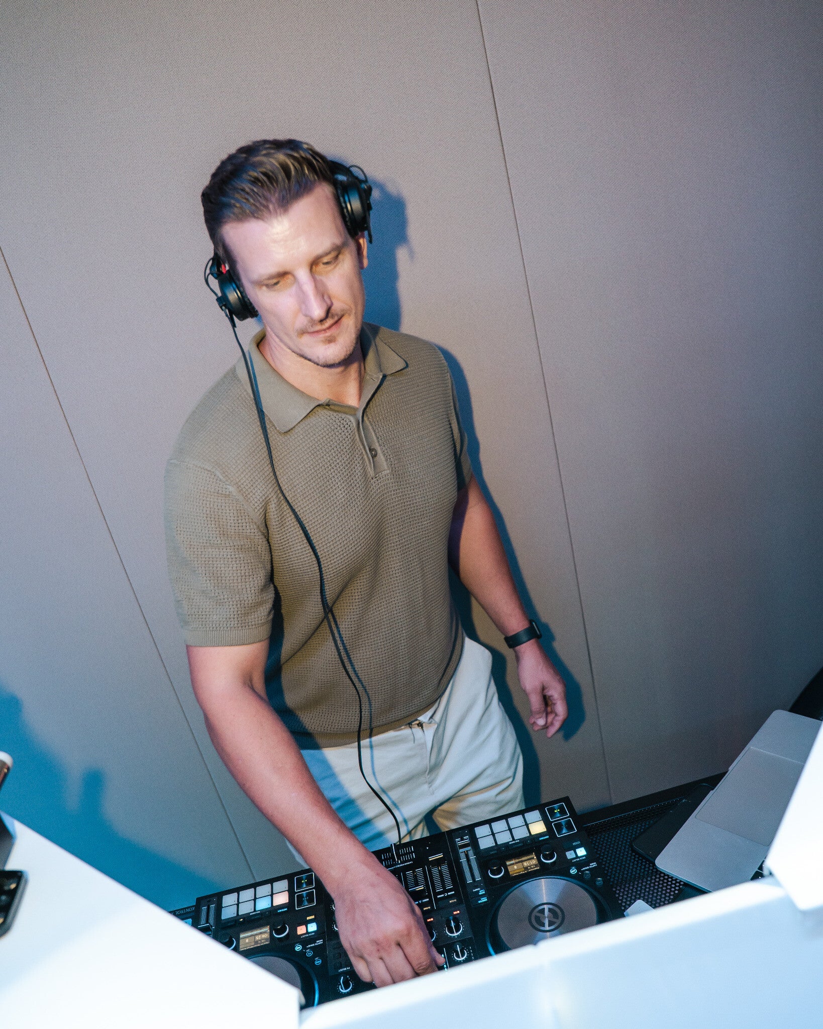 Matt Hall wearing headphones and mixing on the DJ decks