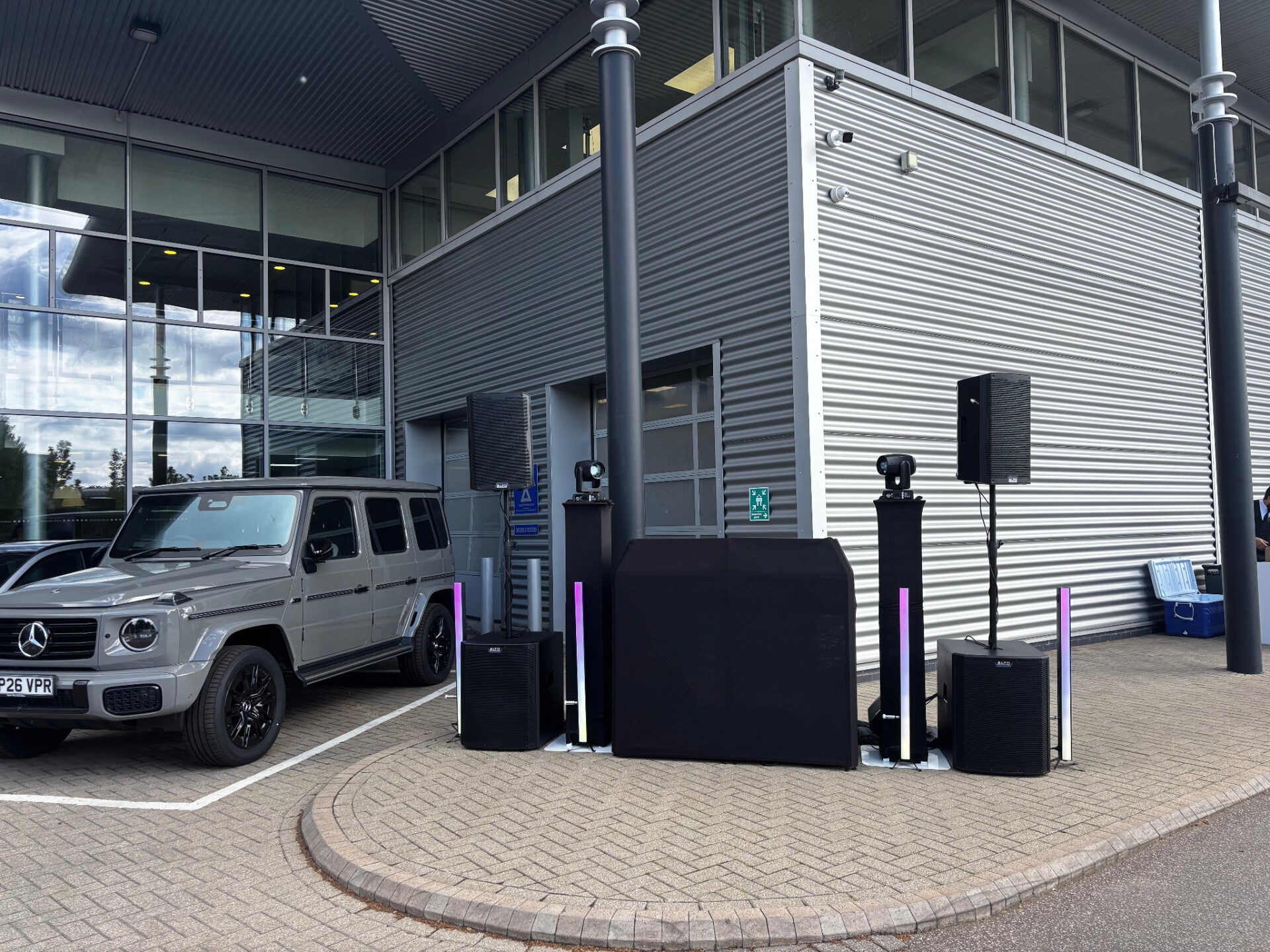 MHX black DJ setup beside a Mercedes G-Class outside the venue