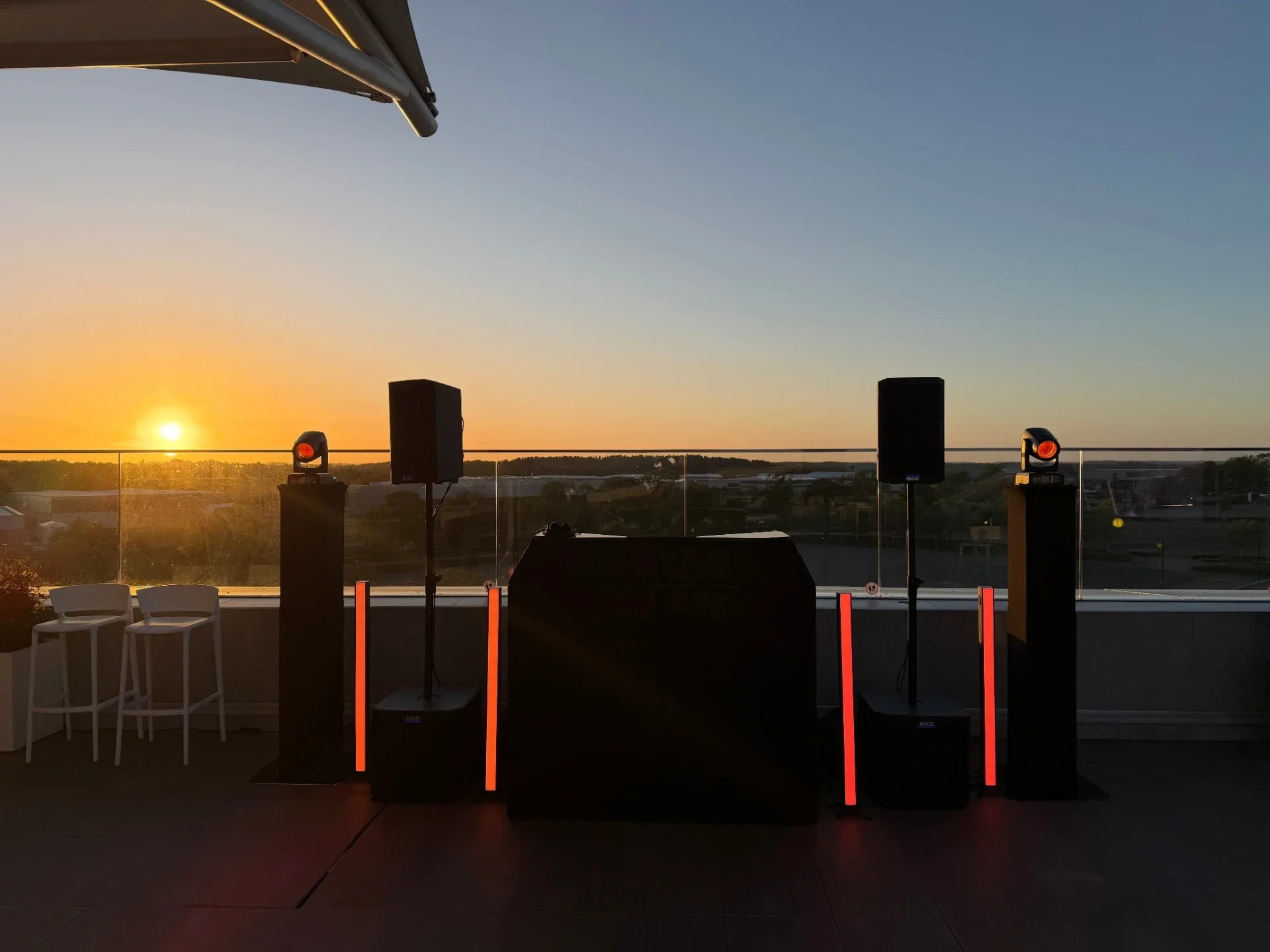 Black MHX DJ booth, speakers and lighting at sunset on the Hilton Garden Inn Silverstone rooftop